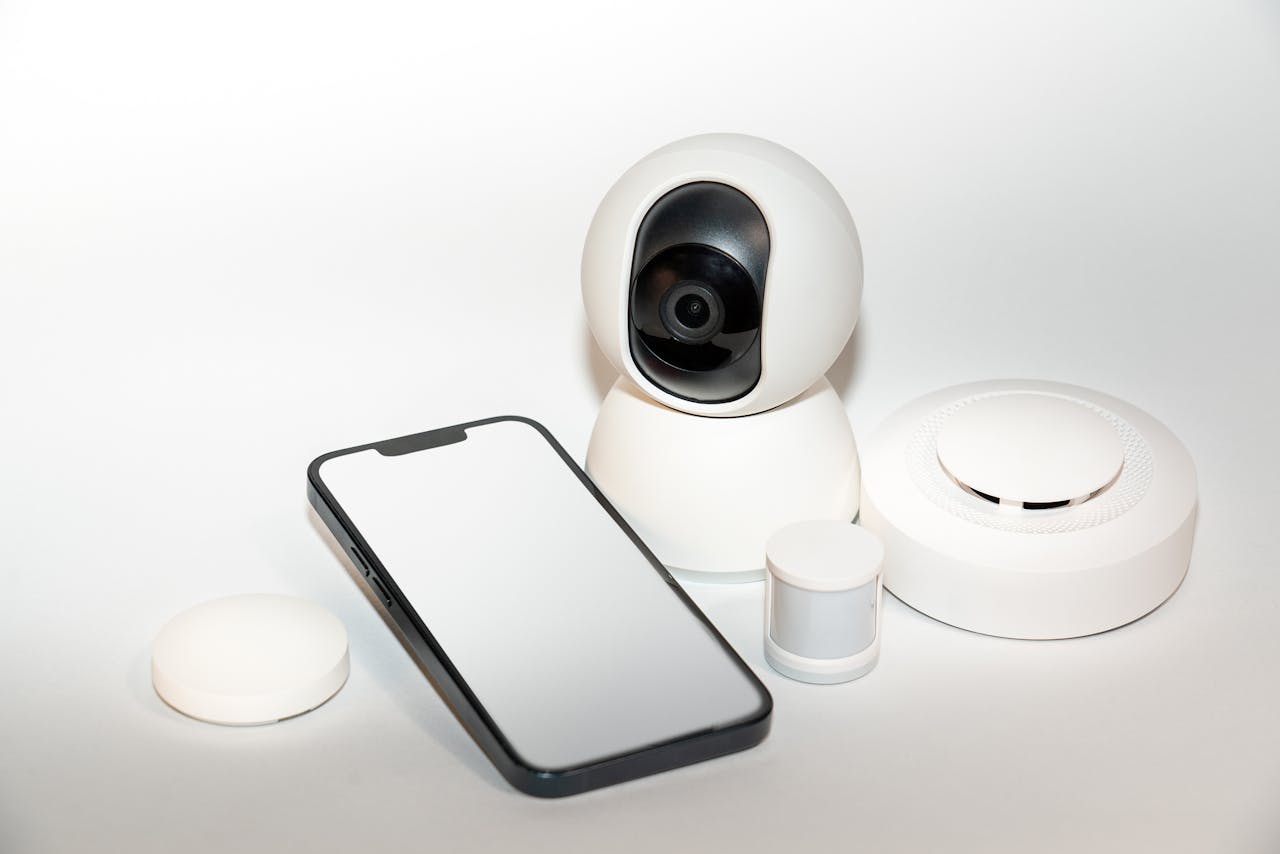 our-story-02 Collection of smart home security gadgets with a smartphone display.